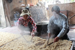 Vật cơm rượu ra phên cho hơi nóng bay hết để rắc men. Ảnh: VGP/Việt Hòa